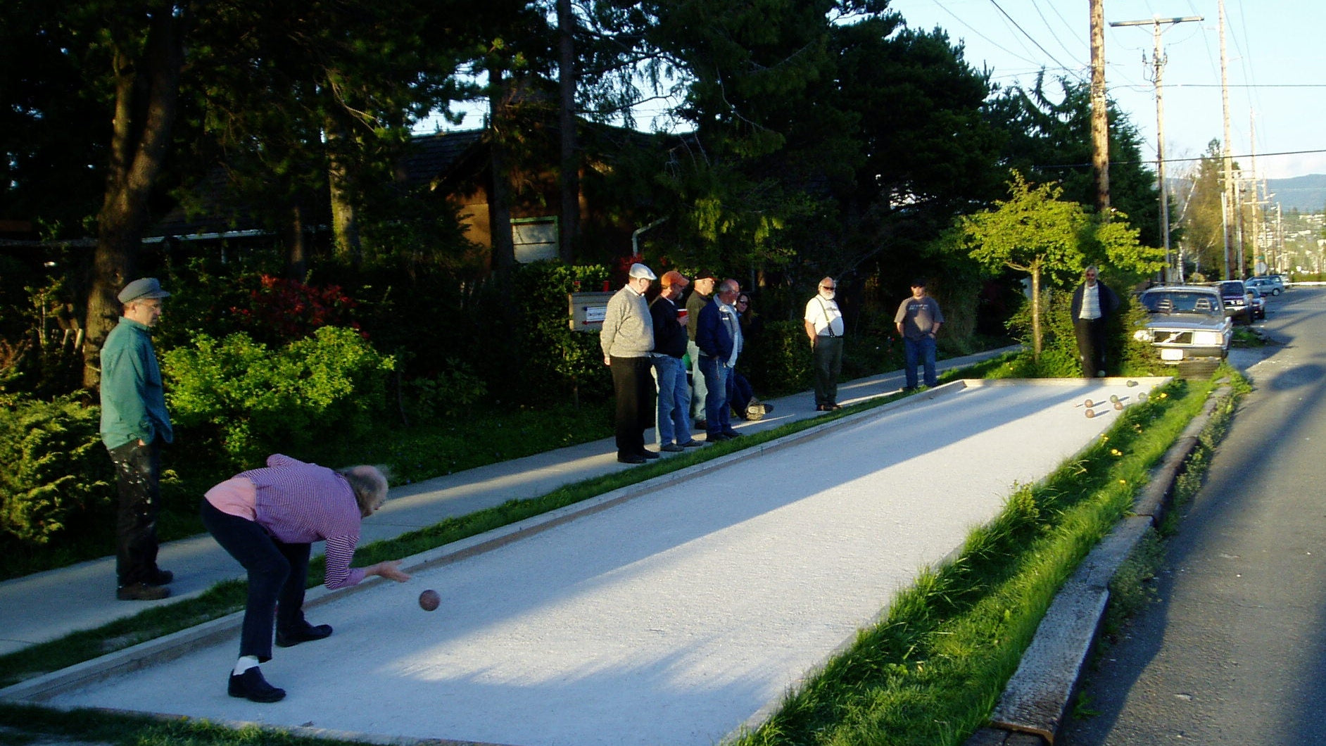 A group of men play bocce on a sidewalk court in Bellingham, WA.